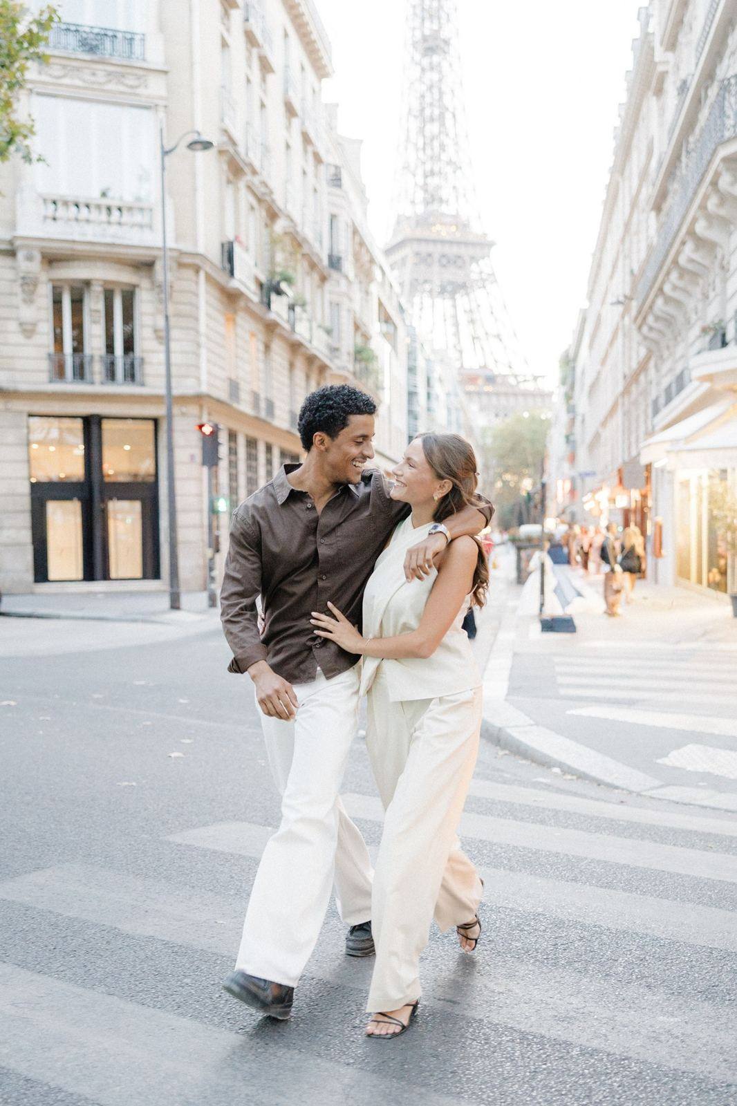 Couple walking arm in arm, the Eiffel Tower behind them