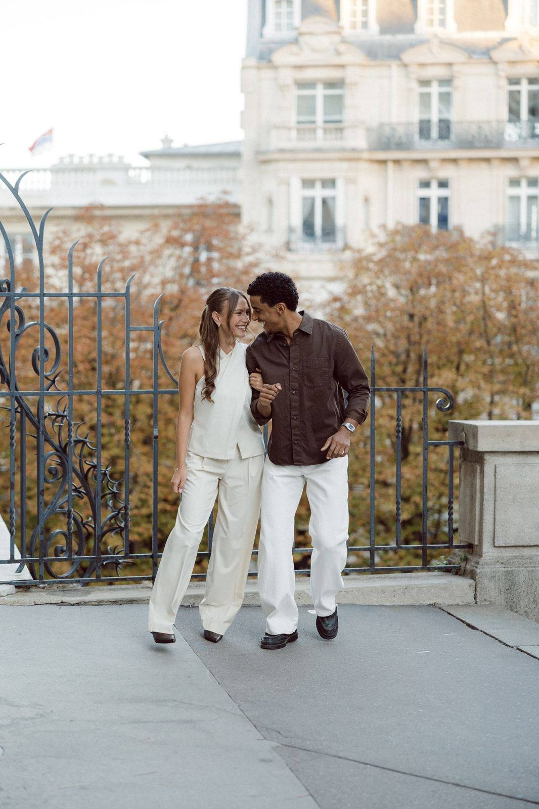 Couple by a wrought-iron railing and autumn leaves, Paris