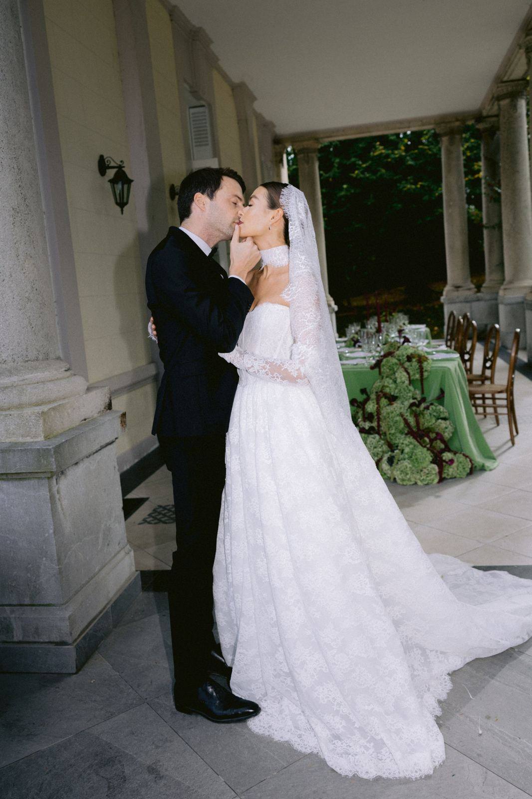 Couple kissing under a stone colonnade