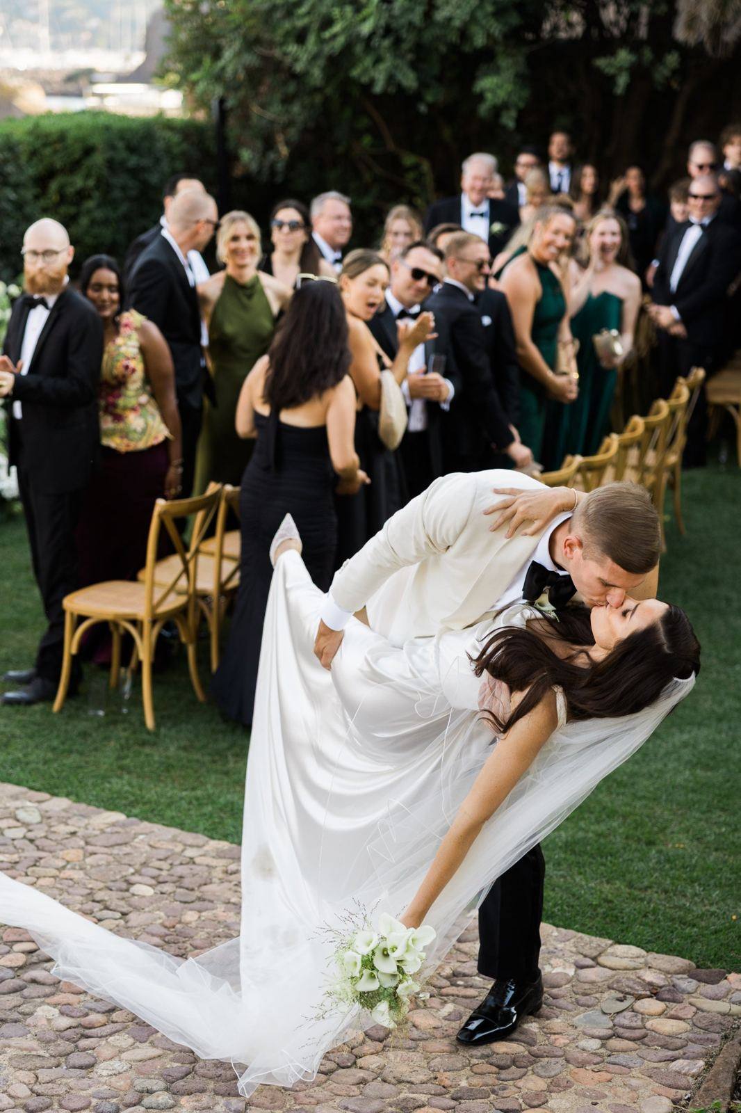 Groom dipping the bride for a kiss in front of the guests