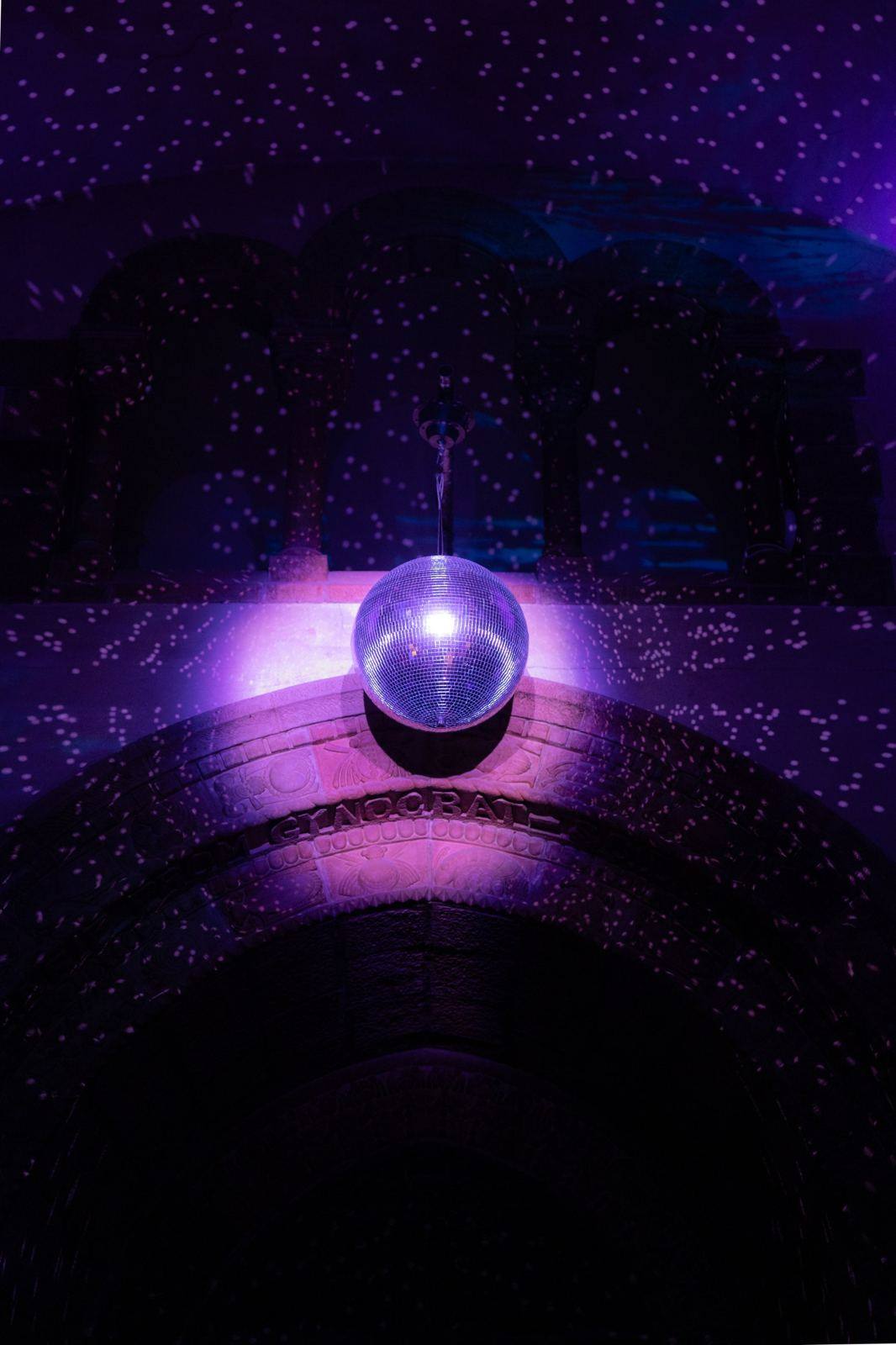 Disco ball above a stone archway