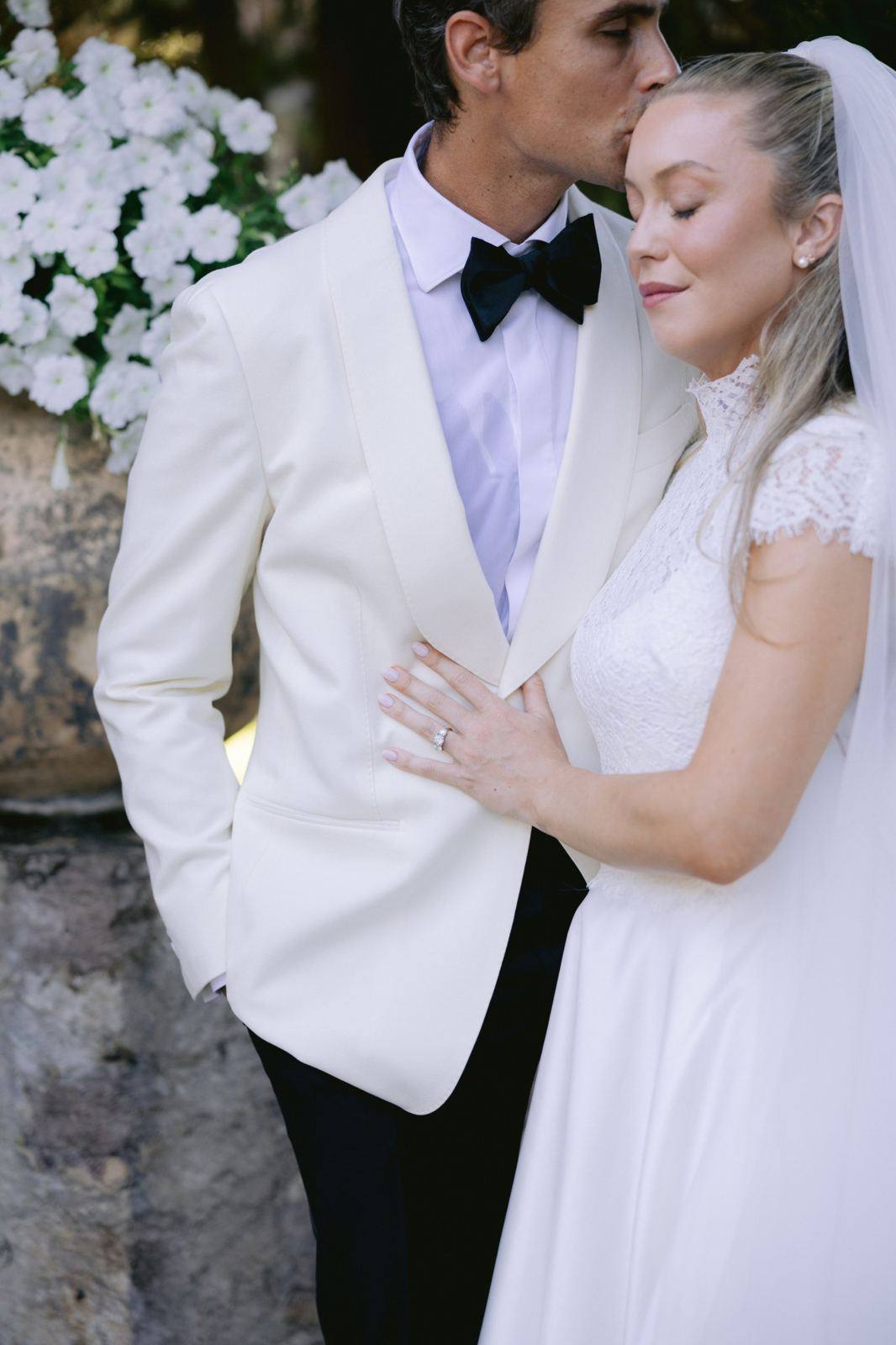 Groom kissing the bride on the forehead